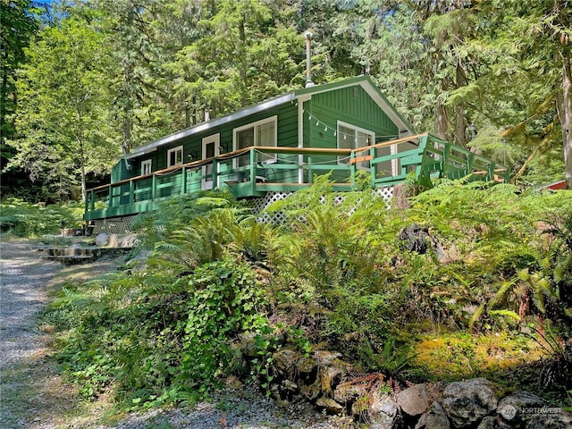 view of front of house with board and batten siding and a forest view