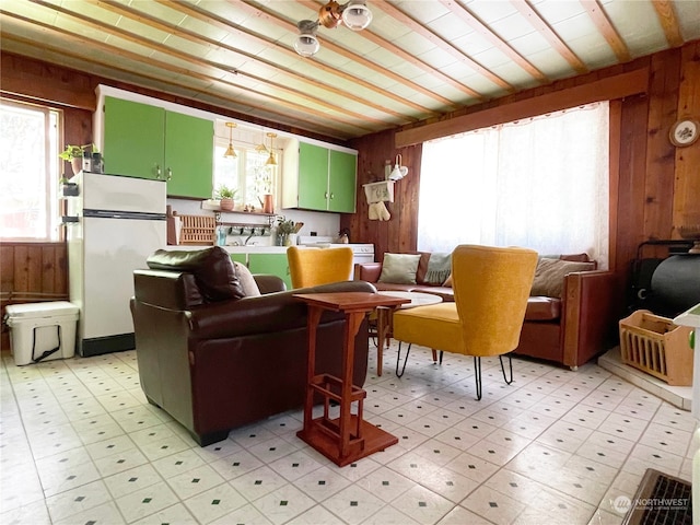 living room featuring wood walls and light tile patterned flooring