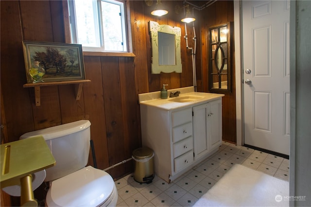 bathroom with vanity, wood walls, tile patterned flooring, and toilet