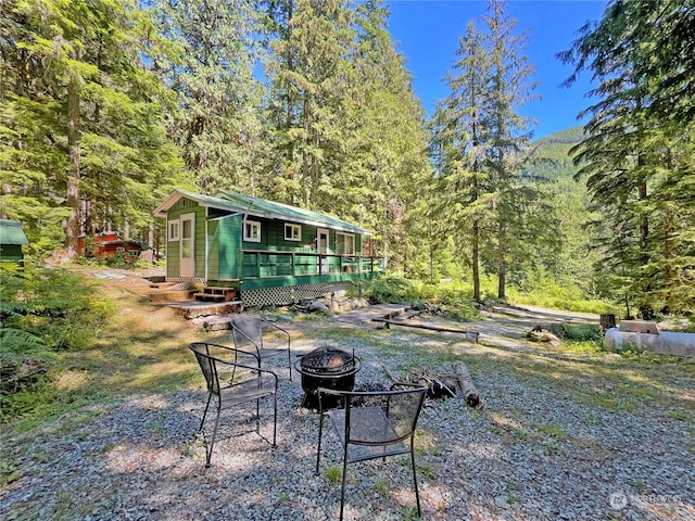 view of yard with a deck, an outbuilding, and an outdoor fire pit