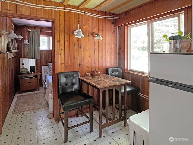 sitting room with plenty of natural light, wood walls, and light tile patterned floors