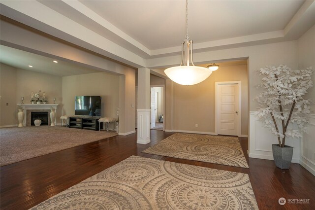 interior space with dark hardwood / wood-style floors and a raised ceiling