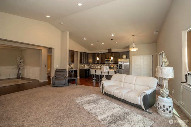 living room featuring high vaulted ceiling and hardwood / wood-style floors