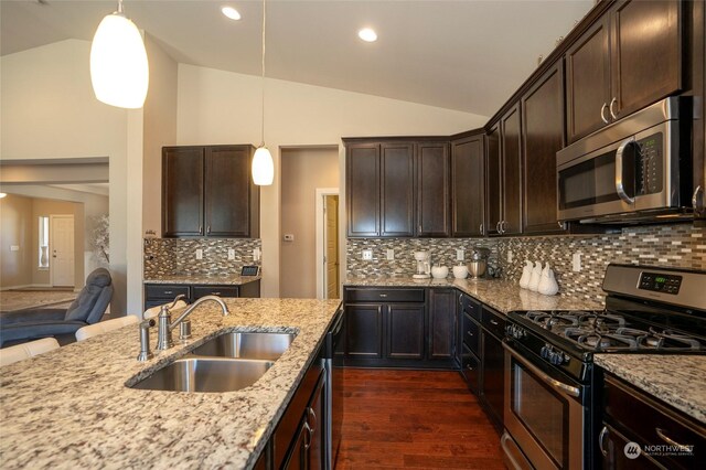 kitchen with stainless steel appliances, vaulted ceiling, sink, dark brown cabinets, and backsplash