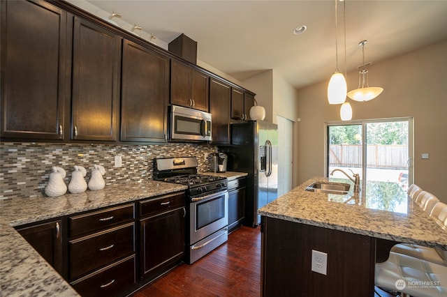 kitchen with tasteful backsplash, a kitchen bar, dark hardwood / wood-style floors, stainless steel appliances, and sink