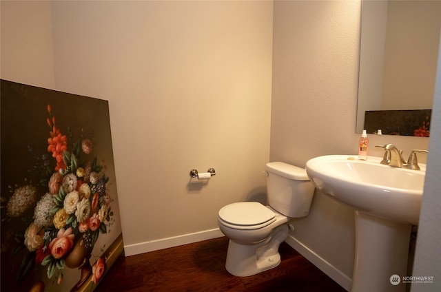 bathroom with hardwood / wood-style flooring and toilet