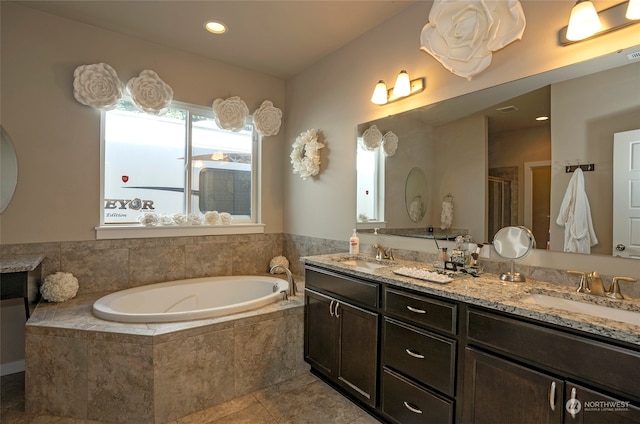 bathroom with tile patterned flooring, tiled tub, and double sink vanity