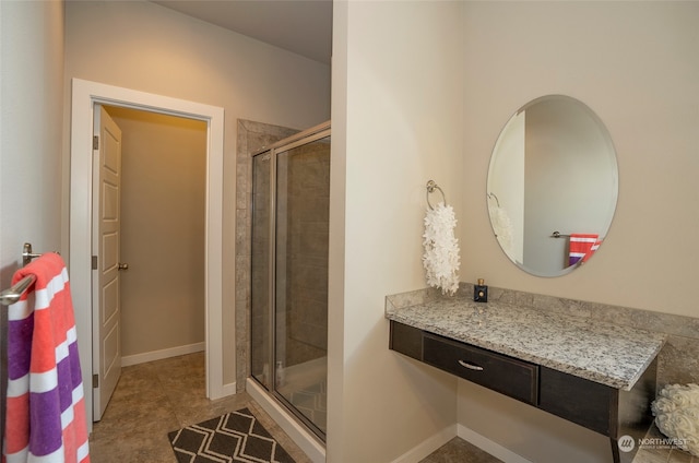 bathroom with tile patterned floors, vanity, and a shower with door