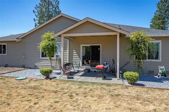 back of property with a patio area and a lawn