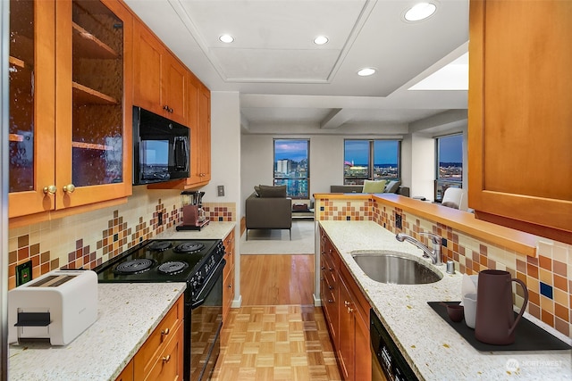 kitchen featuring sink, tasteful backsplash, black appliances, and light stone counters