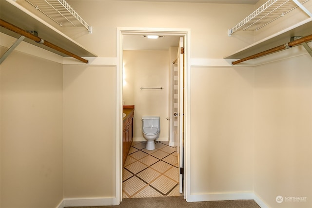 walk in closet featuring light carpet