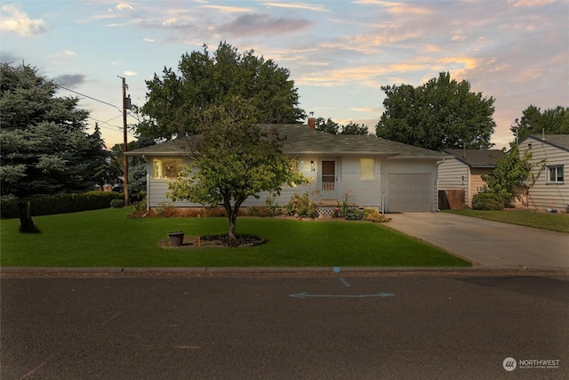 single story home with a lawn, an attached garage, and driveway