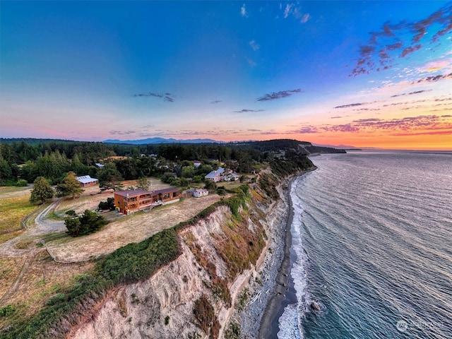 aerial view at dusk featuring a water view