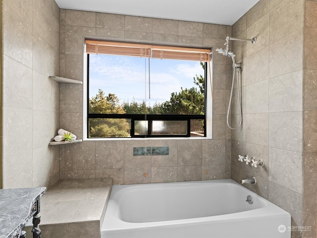 bathroom featuring a wealth of natural light and tiled shower / bath combo