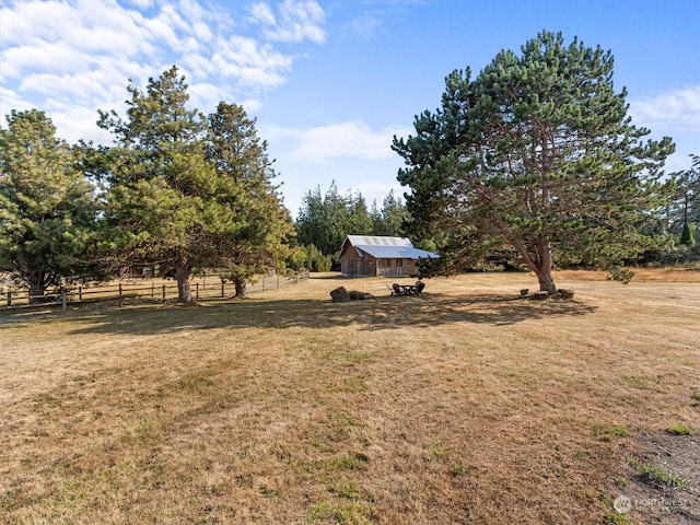 view of yard with a rural view and an outbuilding