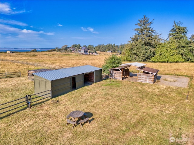 view of outbuilding featuring a lawn and a rural view