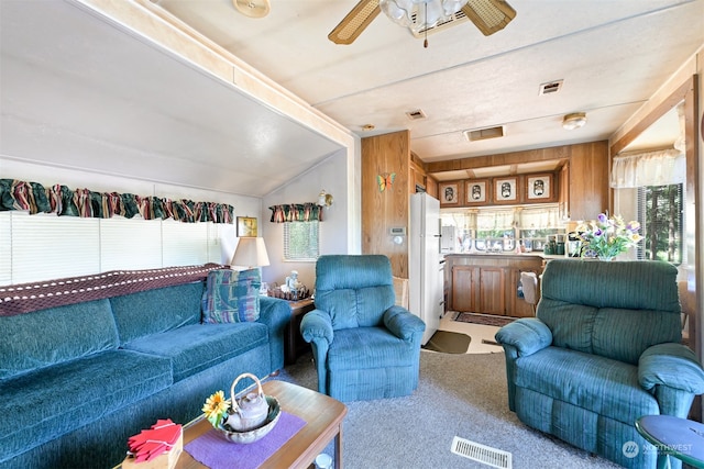 living room featuring wood walls, carpet floors, ceiling fan, and vaulted ceiling