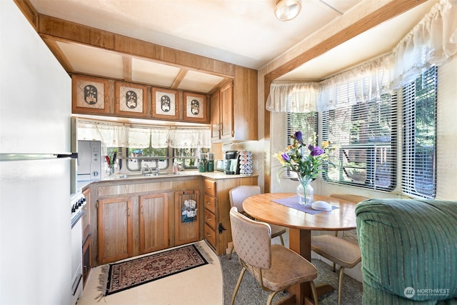 kitchen with tile patterned flooring, white refrigerator, and sink