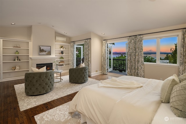 bedroom featuring lofted ceiling, a water view, access to outside, dark hardwood / wood-style flooring, and a wall unit AC