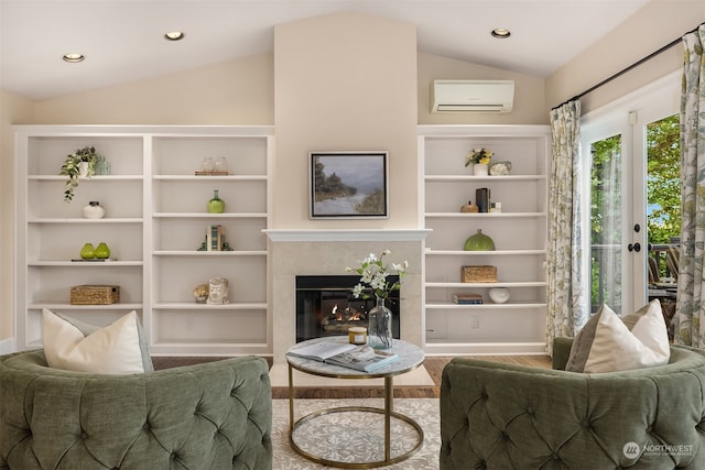 living room with lofted ceiling, hardwood / wood-style floors, a premium fireplace, and an AC wall unit