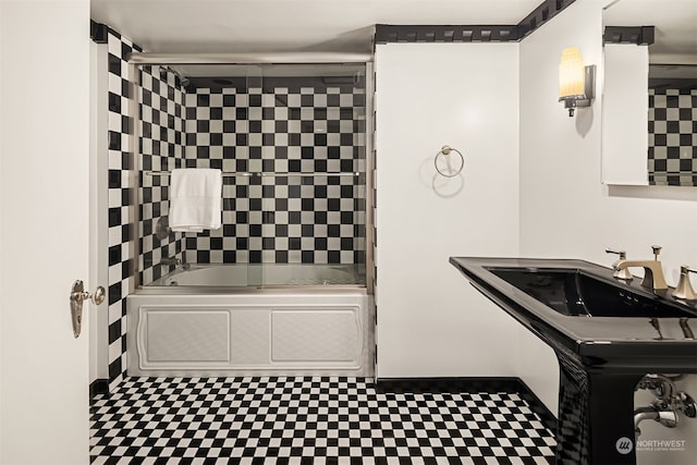 bathroom with bath / shower combo with glass door