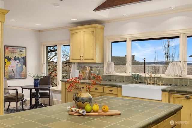 kitchen featuring light brown cabinetry, sink, tasteful backsplash, crown molding, and tile countertops