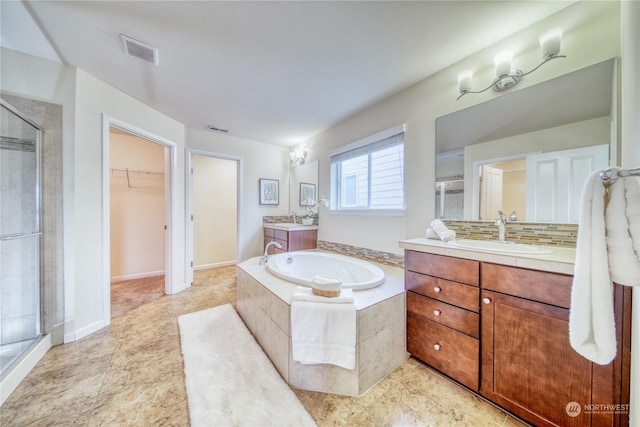 bathroom with decorative backsplash, vanity, tile patterned flooring, and shower with separate bathtub