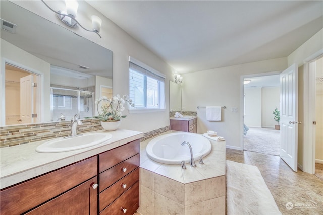 bathroom with tile patterned flooring, backsplash, vanity, and plus walk in shower