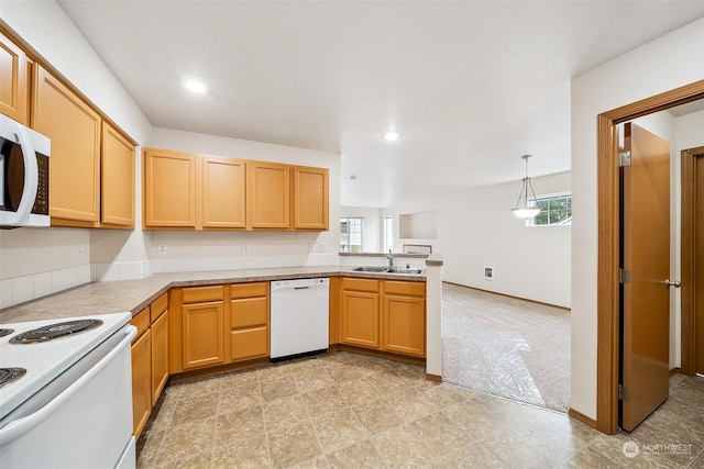 kitchen with pendant lighting, white appliances, sink, and a wealth of natural light