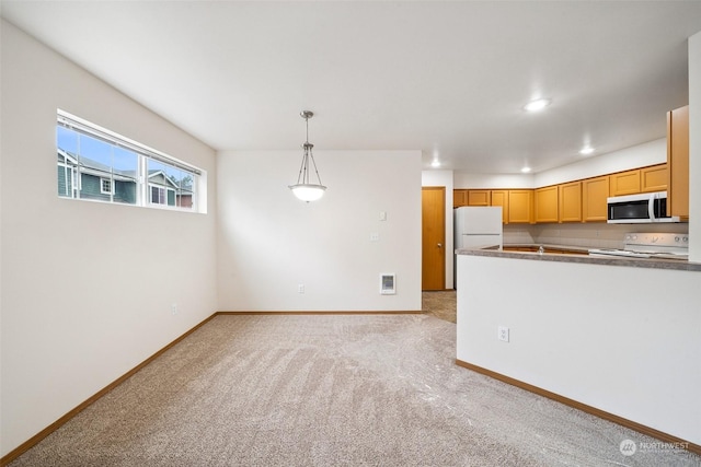 kitchen with light carpet, hanging light fixtures, and white appliances