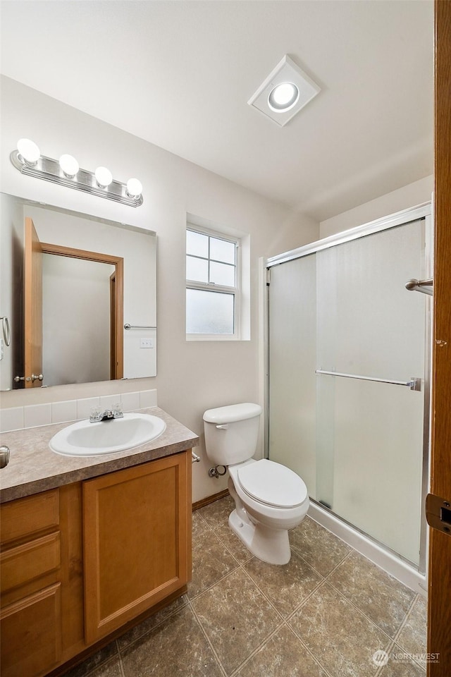 bathroom featuring an enclosed shower, vanity, and toilet