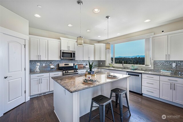 kitchen featuring a center island, dark hardwood / wood-style floors, tasteful backsplash, and stainless steel appliances