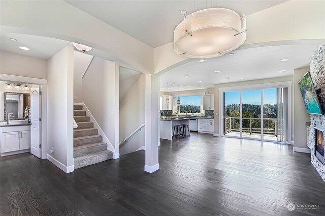 unfurnished living room featuring a fireplace and dark wood-type flooring