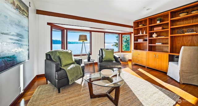 sitting room with a water view and dark hardwood / wood-style flooring