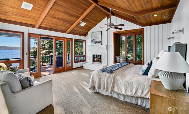 bedroom with a water view, multiple windows, carpet, and access to outside