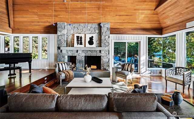 interior space with high vaulted ceiling, wood-type flooring, a fireplace, and wooden ceiling