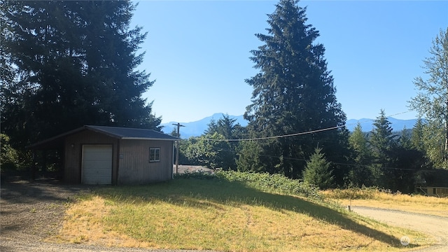 view of yard with a garage and an outbuilding