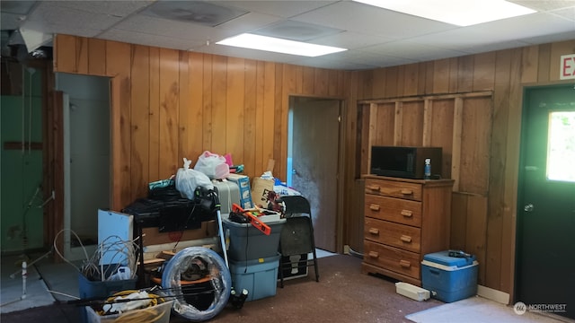 miscellaneous room with wood walls and a drop ceiling