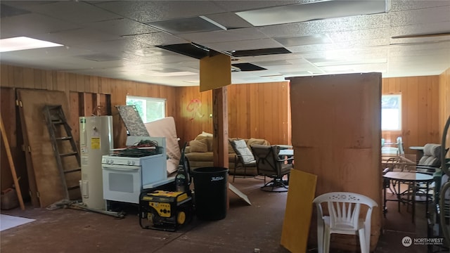 miscellaneous room with wood walls, water heater, and a paneled ceiling