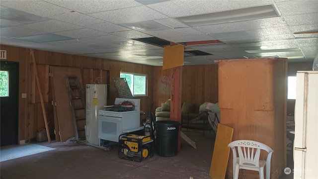 basement with white refrigerator, water heater, and a paneled ceiling