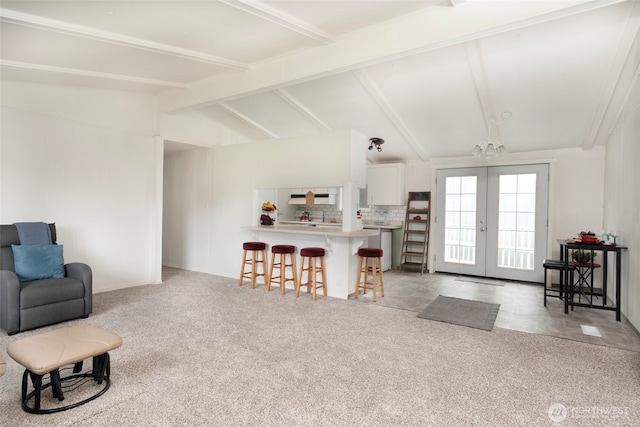 living area with french doors, light carpet, and vaulted ceiling with beams