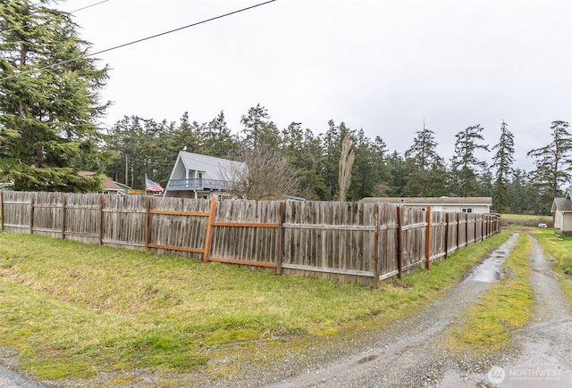 view of yard with driveway and fence