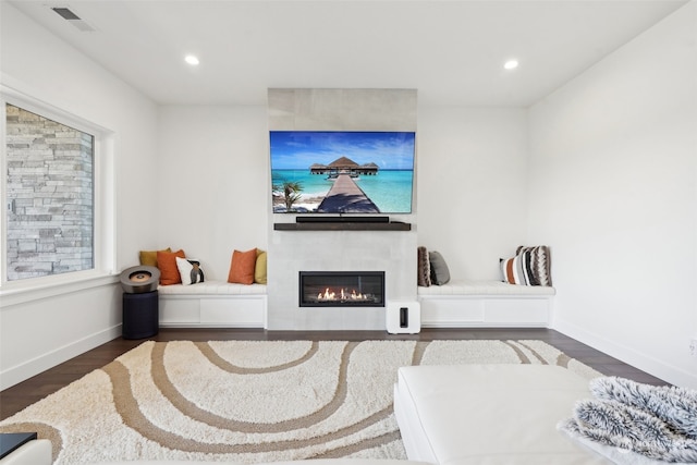 living room with a fireplace and dark wood-type flooring