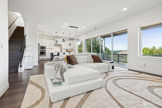 living room featuring sink, a healthy amount of sunlight, hardwood / wood-style flooring, and a chandelier