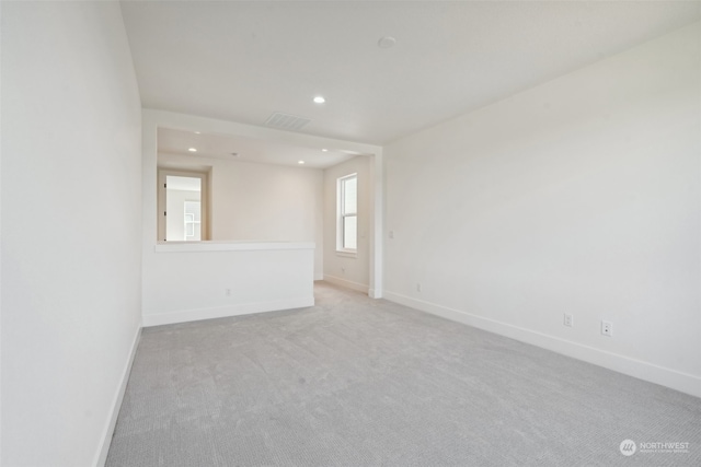 unfurnished room featuring light carpet