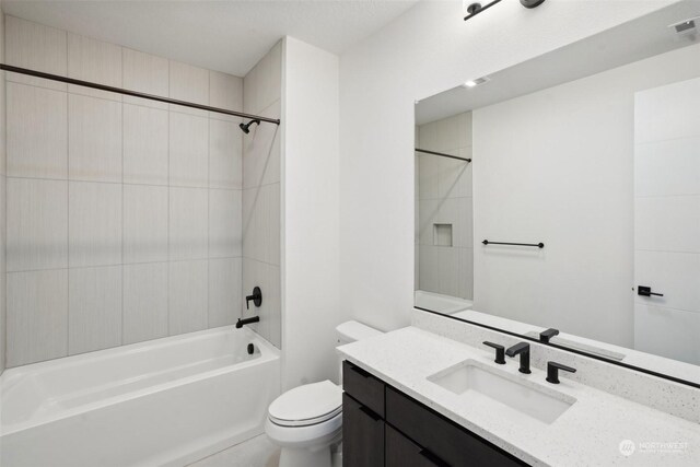 full bathroom featuring vanity, tiled shower / bath, and toilet