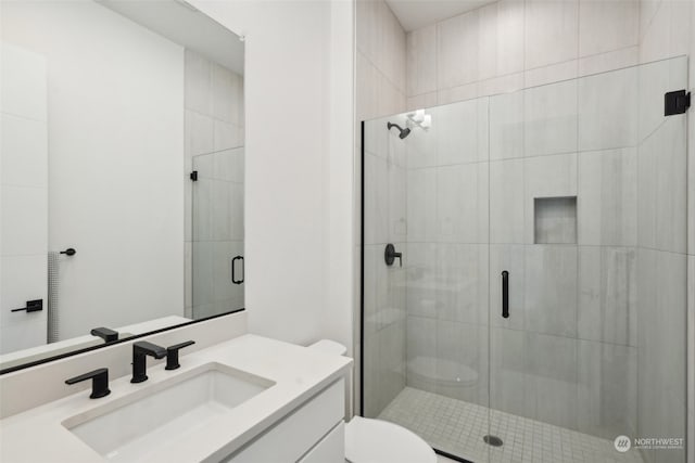 bathroom with walk in shower, toilet, and vanity