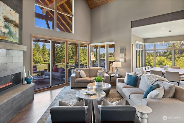 living room with hardwood / wood-style flooring, high vaulted ceiling, wooden ceiling, and an inviting chandelier