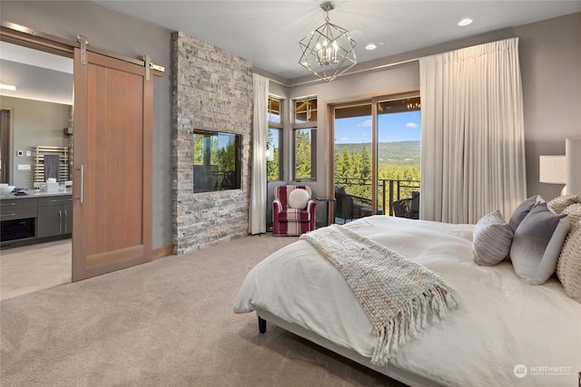 bedroom with ensuite bathroom, a chandelier, access to outside, light colored carpet, and a barn door