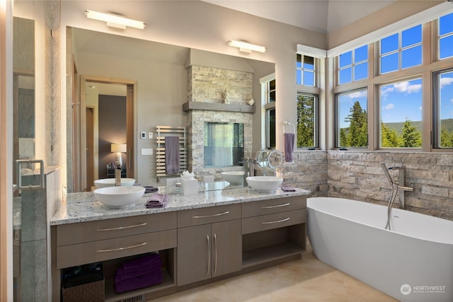 bathroom with vanity, tile patterned flooring, tile walls, and a tub